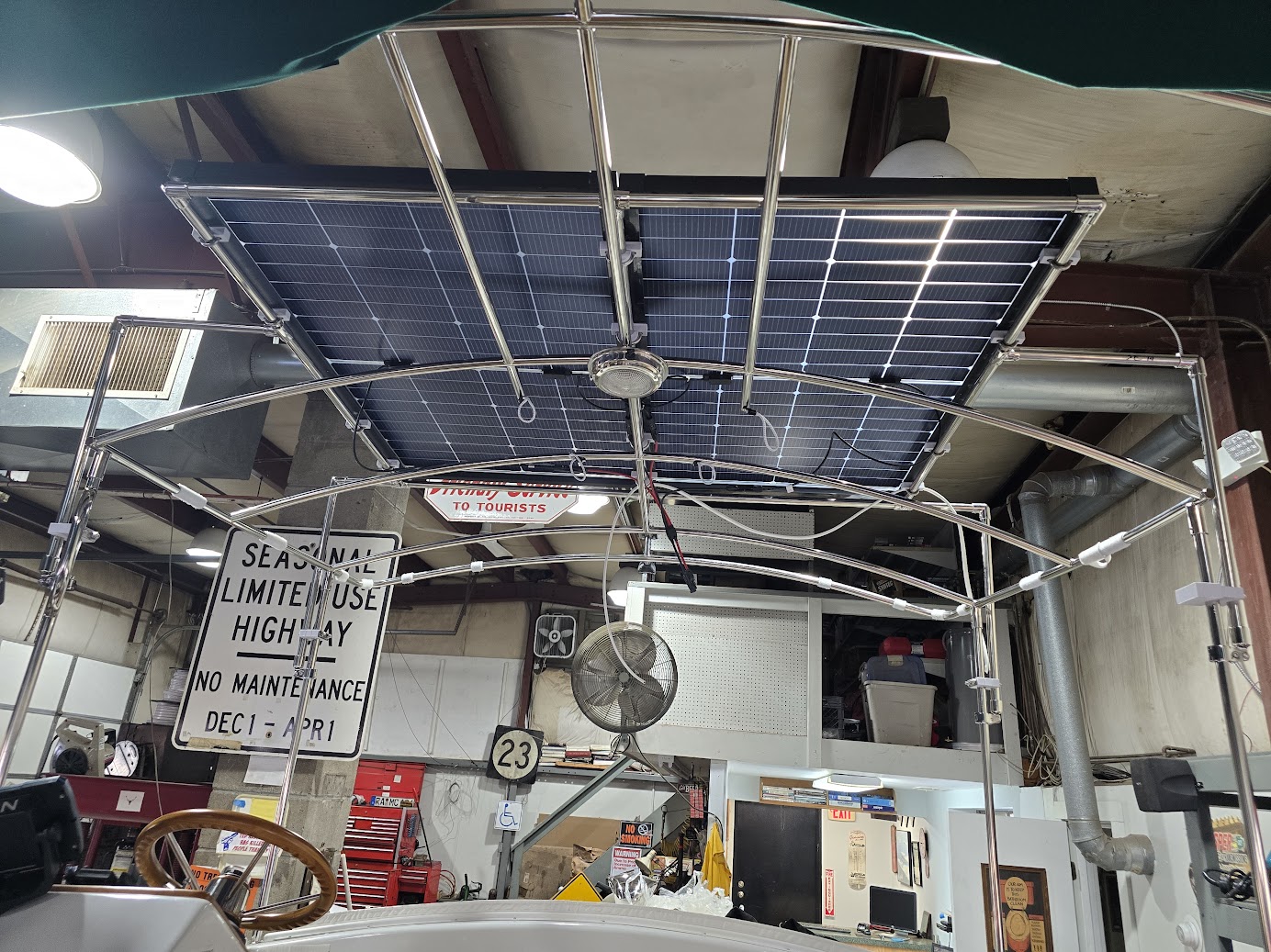 Custom stainless solar panel mounting structure beneath a boat canopy