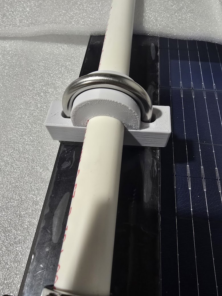 White 3D-printed clamp installed around tubing on a solar-panel assembly