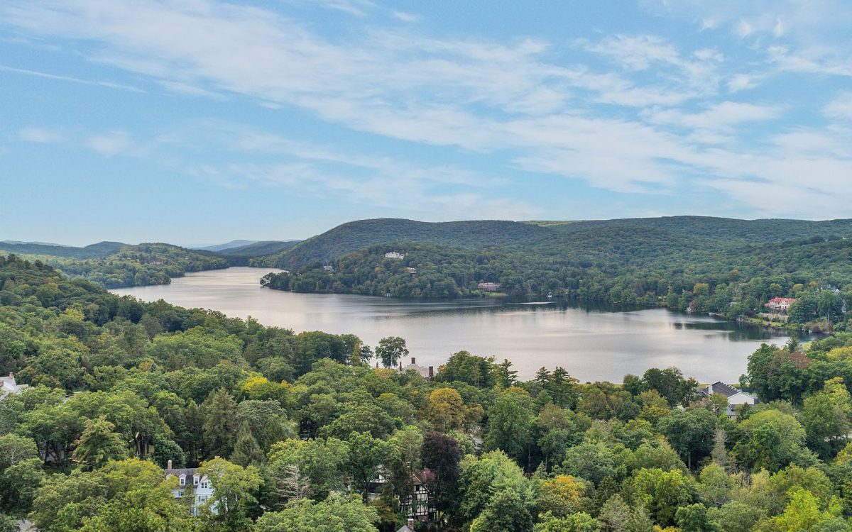 Panoramic summer view of Tuxedo Lake surrounded by wooded hills and homes